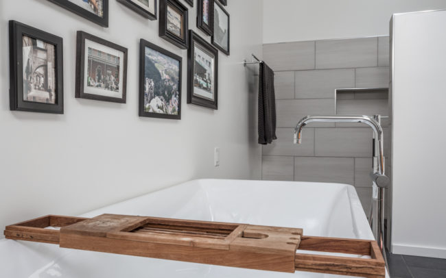 A bathroom with a bathtub and framed pictures.